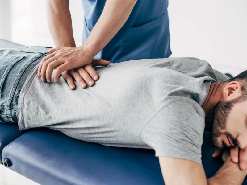 Dr. Brett chavez gives a chiropractic adjustment to a lubbock, tx patient to relieve back pain.